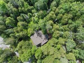 Vista aérea de un edificio cuadrado rodeado de un bosque frondoso.