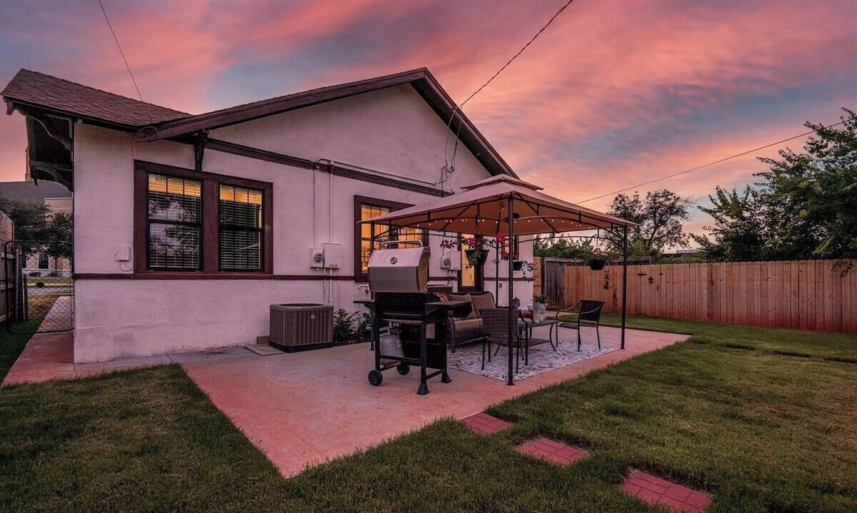 Une maison dotée d’un patio couvert, d’un barbecue et de mobilier d’extérieur.
