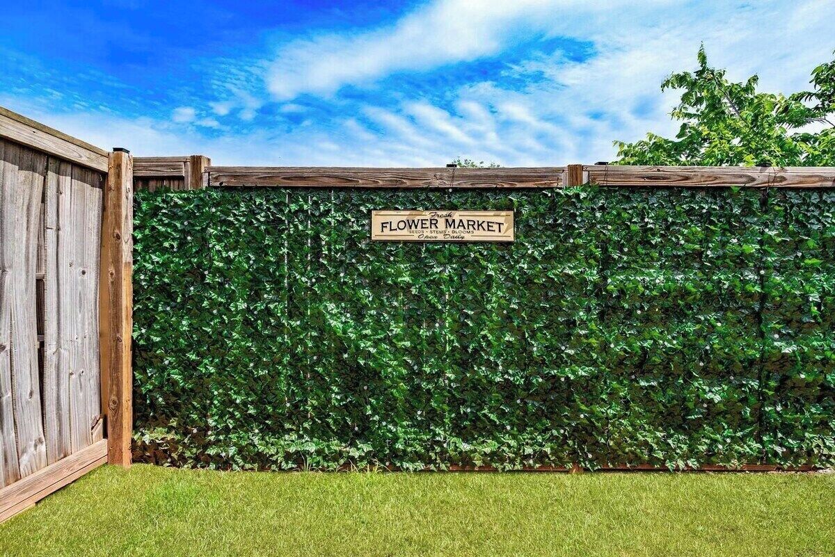 A wooden fence with a sign that reads 'Flower Market.'