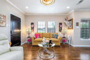 Un salón con sofá, una mesa de centro y elementos decorativos.