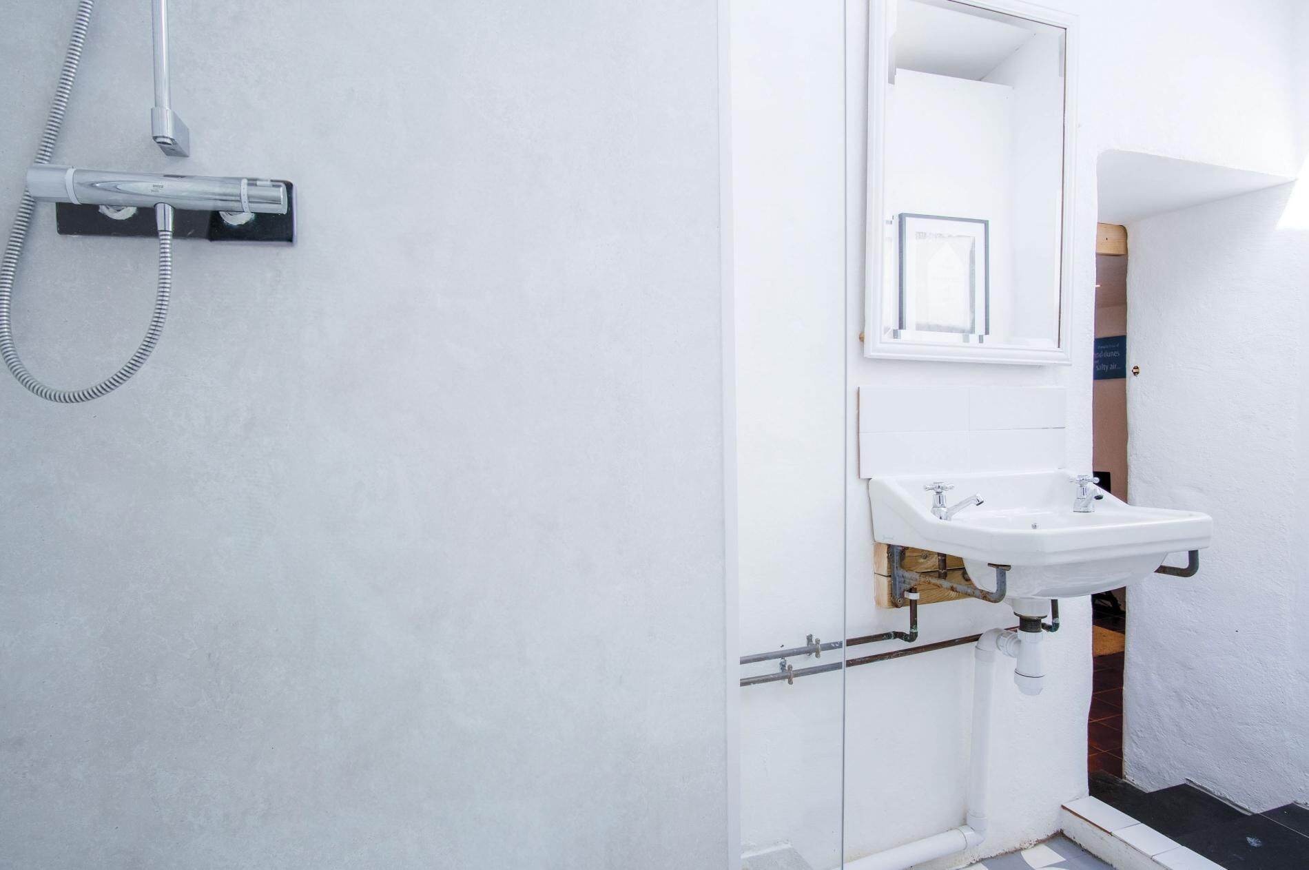A bathroom with a shower, sink, and mirror.