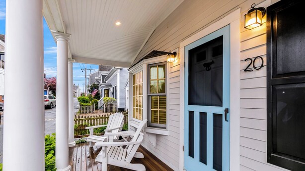A porch with two Adirondack chairs, a white door with a number, and a small garden area. - Dog-Friendly West End Home + Parking - Sleeps 6 (Provincetown)