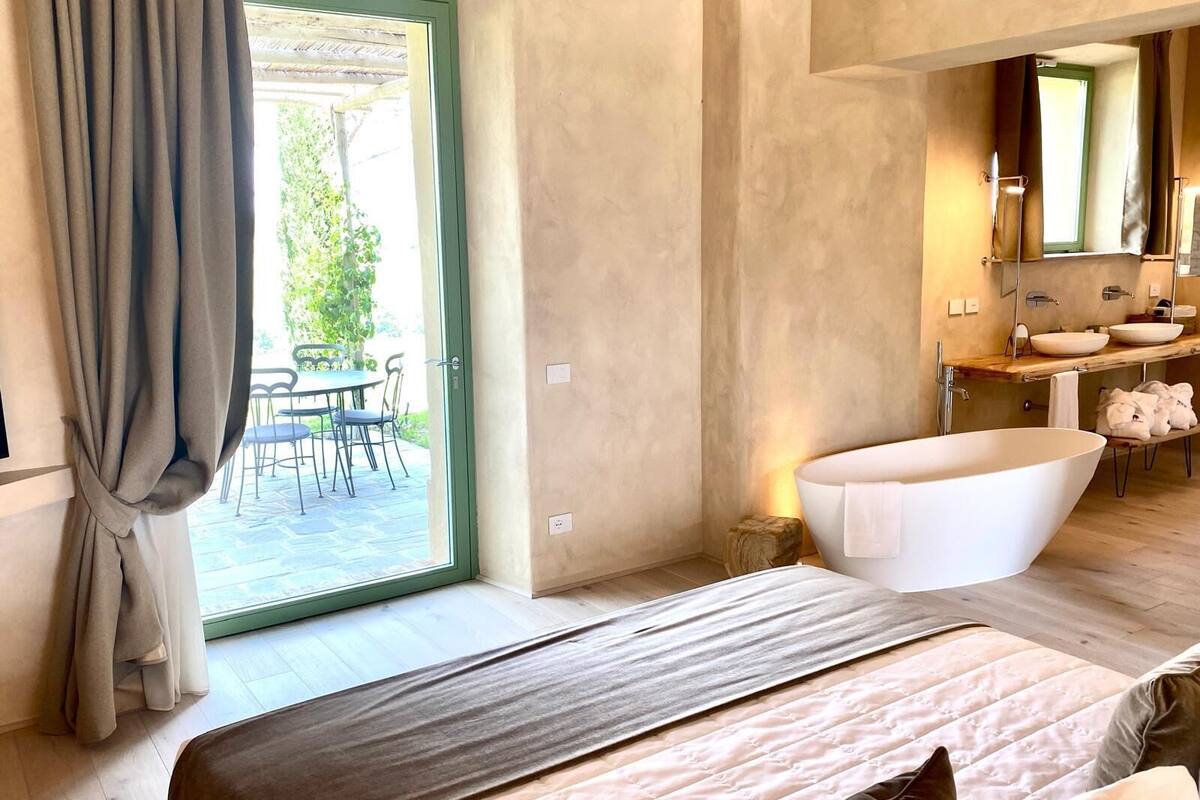 Un baño moderno con una bañera independiente, un tocador doble y un espejo grande.