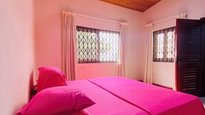 A bedroom with a wooden ceiling, a bed with pink bedding, two windows with curtains, and a ceiling fan. - Charming 3-bedroom house in enchanting Aburi with WiFi, AC (Aburi)