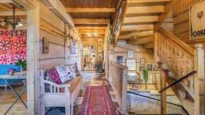 A wooden interior with a bench, a rug, and a staircase. - Leśniczówka u Zięby (Koscielisko)