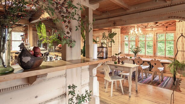 A rustic wooden interior with a dining area, wooden chairs, a table, and a chandelier. - Leśniczówka u Zięby (Koscielisko)