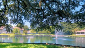 Un parc paisible avec un étang, des arbres et un kiosque.