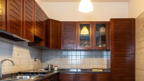 Uma cozinha compacta com armários de madeira, uma pia de aço inoxidável e um forno embutido.