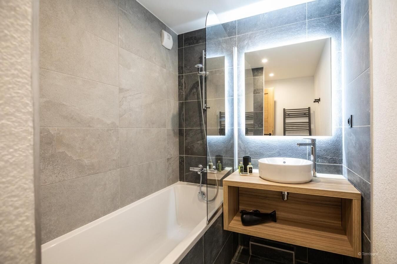 A modern bathroom with a bathtub, a sink, and a glass-enclosed shower area.