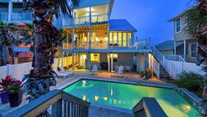 A two-story house with a pool, outdoor seating, and a covered patio area. - Gulf-front, Private Pool ~ Stunning Gulf Views From All Levels + Beach Setup (Panama City Beach)