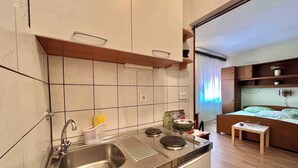 A compact kitchen with a sink, stove, and cabinets. - Studio with air conditioning and with terrace (Dramalj)