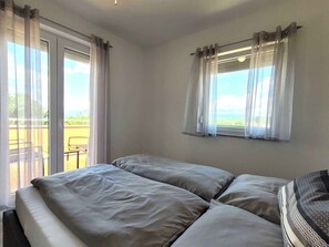 A room with two beds, a balcony, and a window with curtains. - Holiday flat with balcony (Sveti Anton/Insel Krk)
