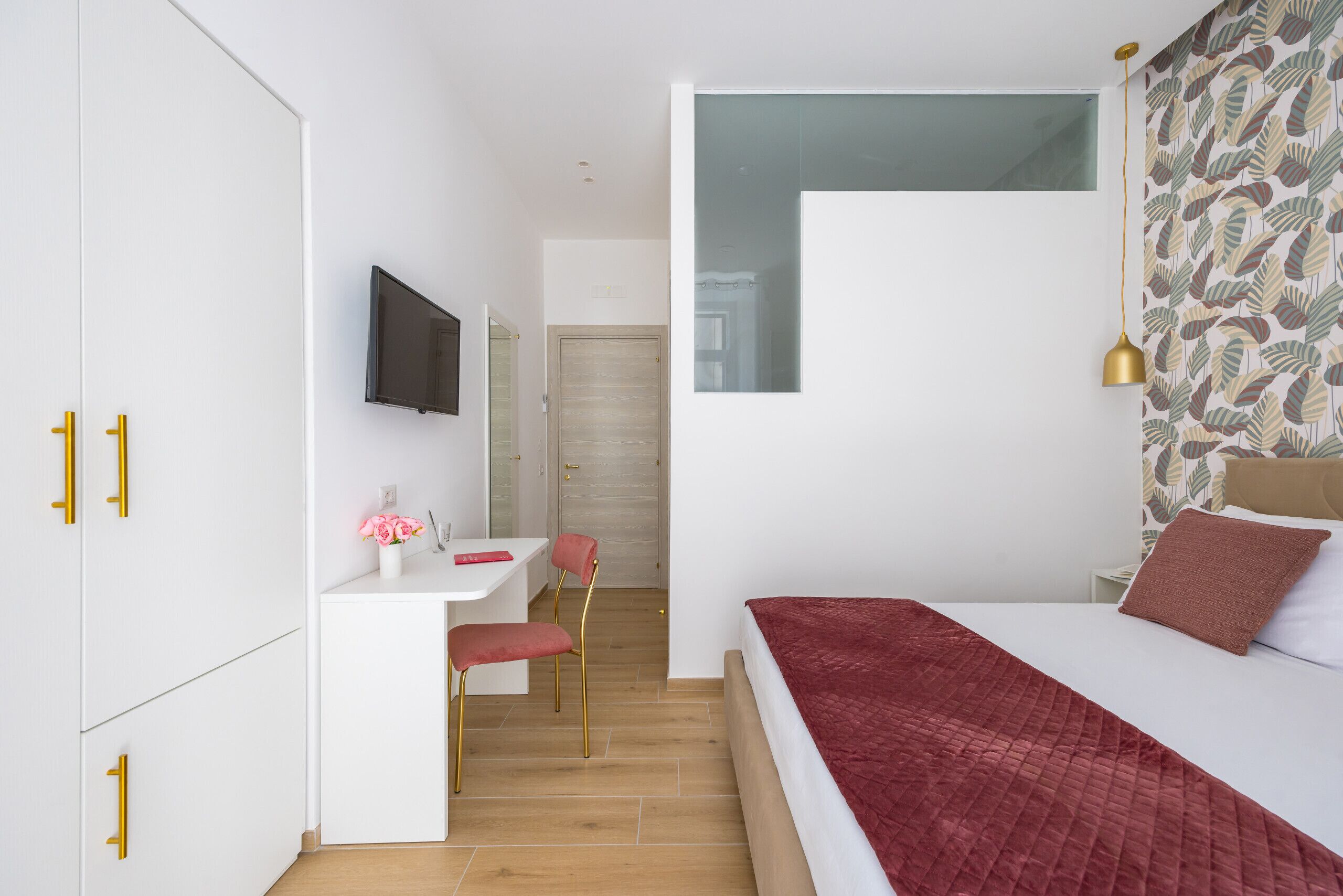 A modern bedroom with a bed, a desk, and a chair.
