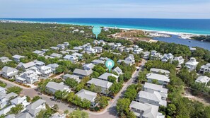 Vista aérea de uma área residencial com casas, praia e oceano à vista.