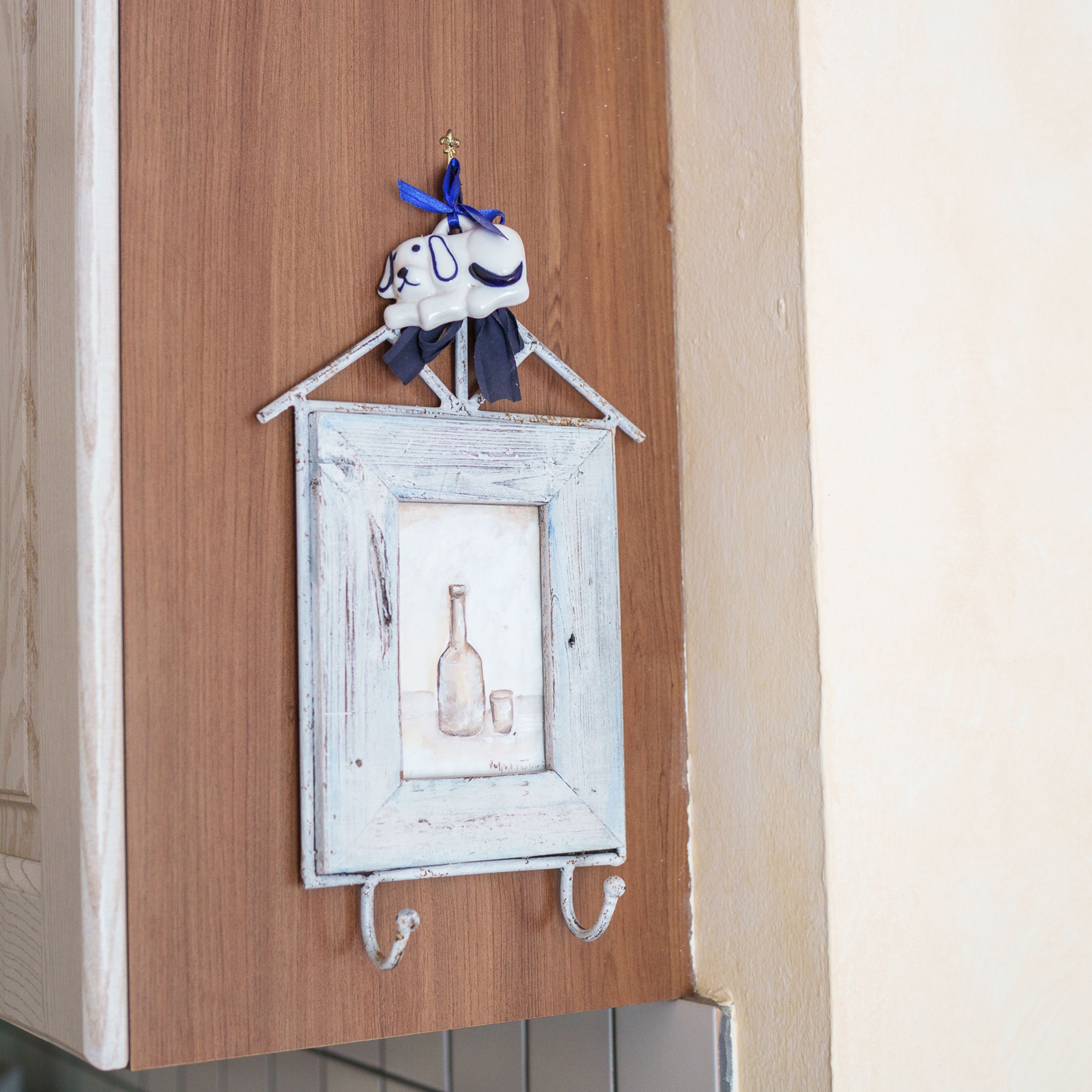 Decoración rústica montada en la pared, con un pequeño cuadro de una botella y una copa.
