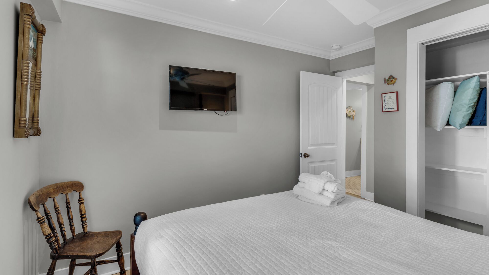 Une chambre à coucher avec un lit, une chaise, une télévision et une armoire.