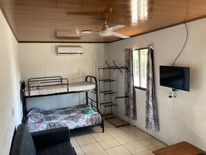 Cozy retreat with a bunk bed setup, mounted TV, and ceiling fan.