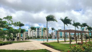 A resort with multiple-story buildings, a swimming pool, and a well-maintained garden area. - Relaxing II, Punta Cana near beaches ✅ (Punta Cana)