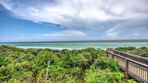 A coastal view with a wooden walkway leading to the beach, surrounded by dense greenery. - Luxury 4-bedroom Vacation Home With Unparalleled Gulf Views (Santa Rosa Beach)