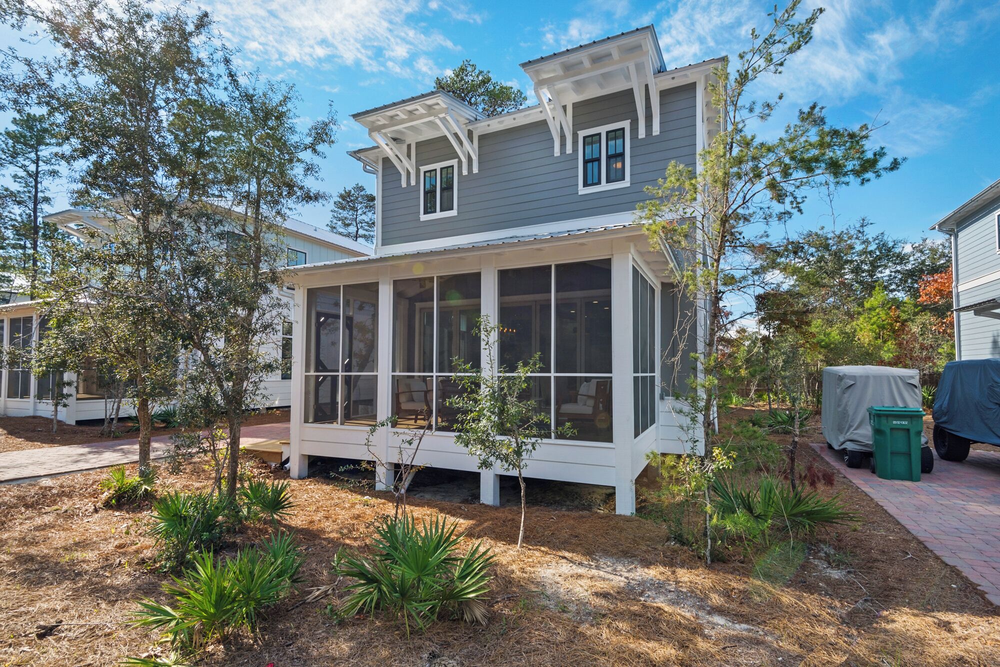 A two-story house with a covered porch and a screened-in area.