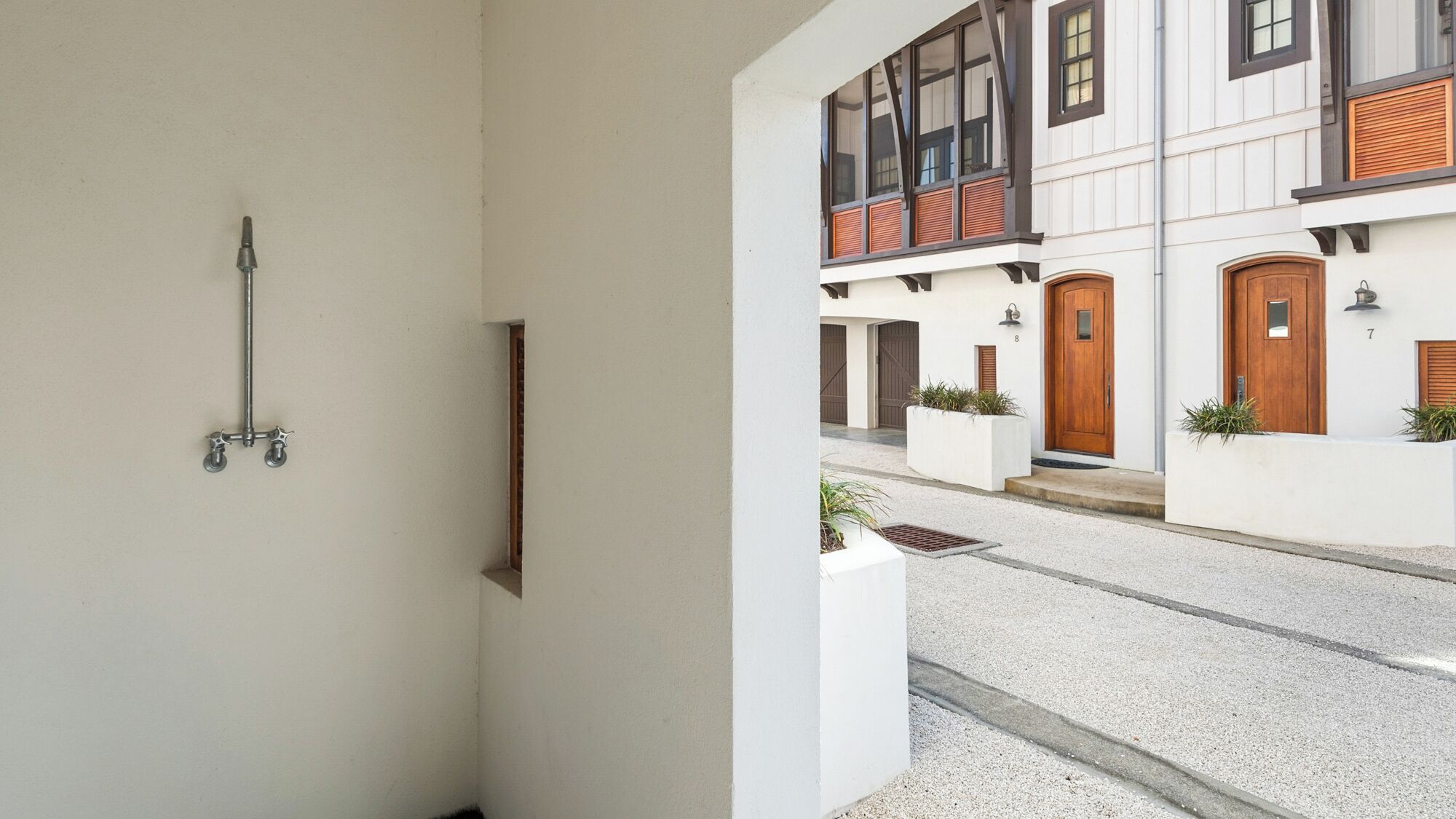 Un edificio moderno con una facciata pulita, una scultura in metallo e un'area ingresso curata.