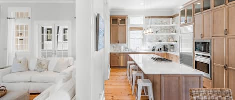 A modern kitchen with wooden cabinets, a central island, and stainless steel appliances.