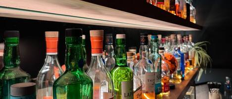 Un bar dont les étagères sont remplies de différentes bouteilles d’alcool.