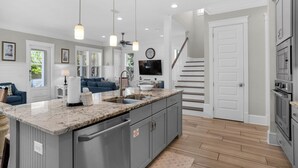 A modern kitchen with a marble countertop, stainless steel appliances, and a built-in oven. - Modern Prominence Home ~ Game Room, 4 Bikes, Sleeps 13, Pet Friendly! (Santa Rosa Beach)