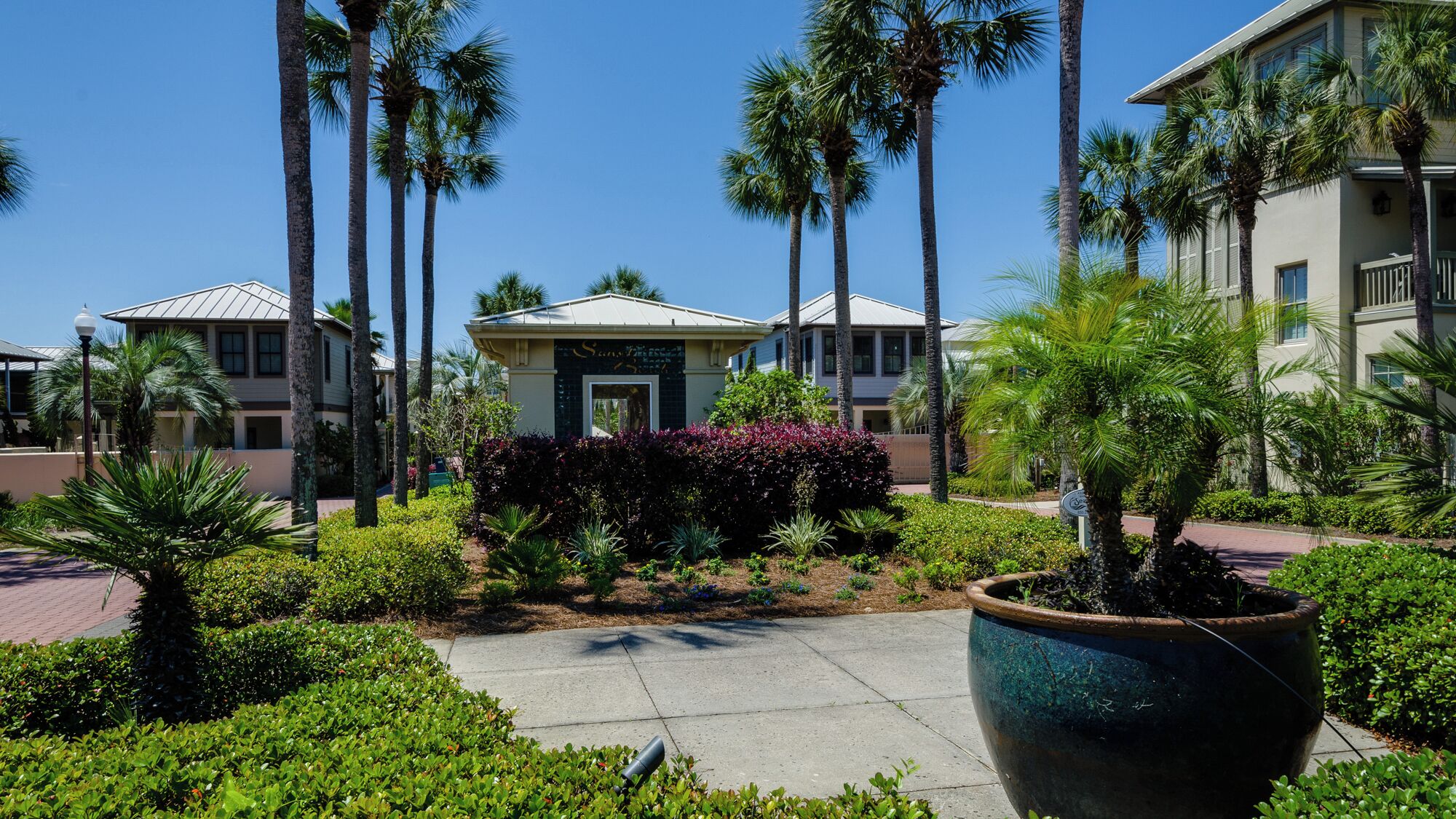 A resort with multiple-story buildings, palm trees, and well-maintained gardens.