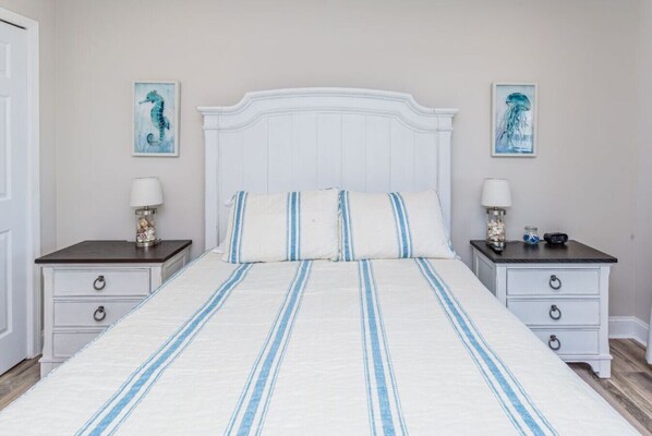 Ein Schlafzimmer mit einem Bett, zwei Nachttischen und zwei Wandleuchten.