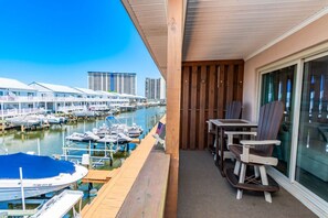 Ein Balkon mit Blick auf einen Yachthafen, mit Holzterrasse und Tisch mit Stühlen.