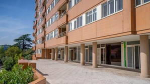 A multi-story hotel with a brick facade, large windows, and a covered entrance area. - Infante Cozy 1BR w/ Parking by LovelyStay (Vila Nova de Gaia)