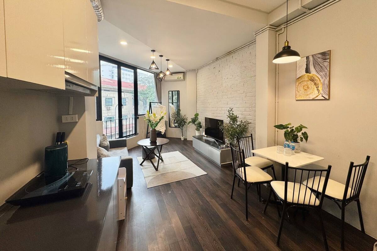 A modern kitchen with a dining area, large windows, and a fireplace.