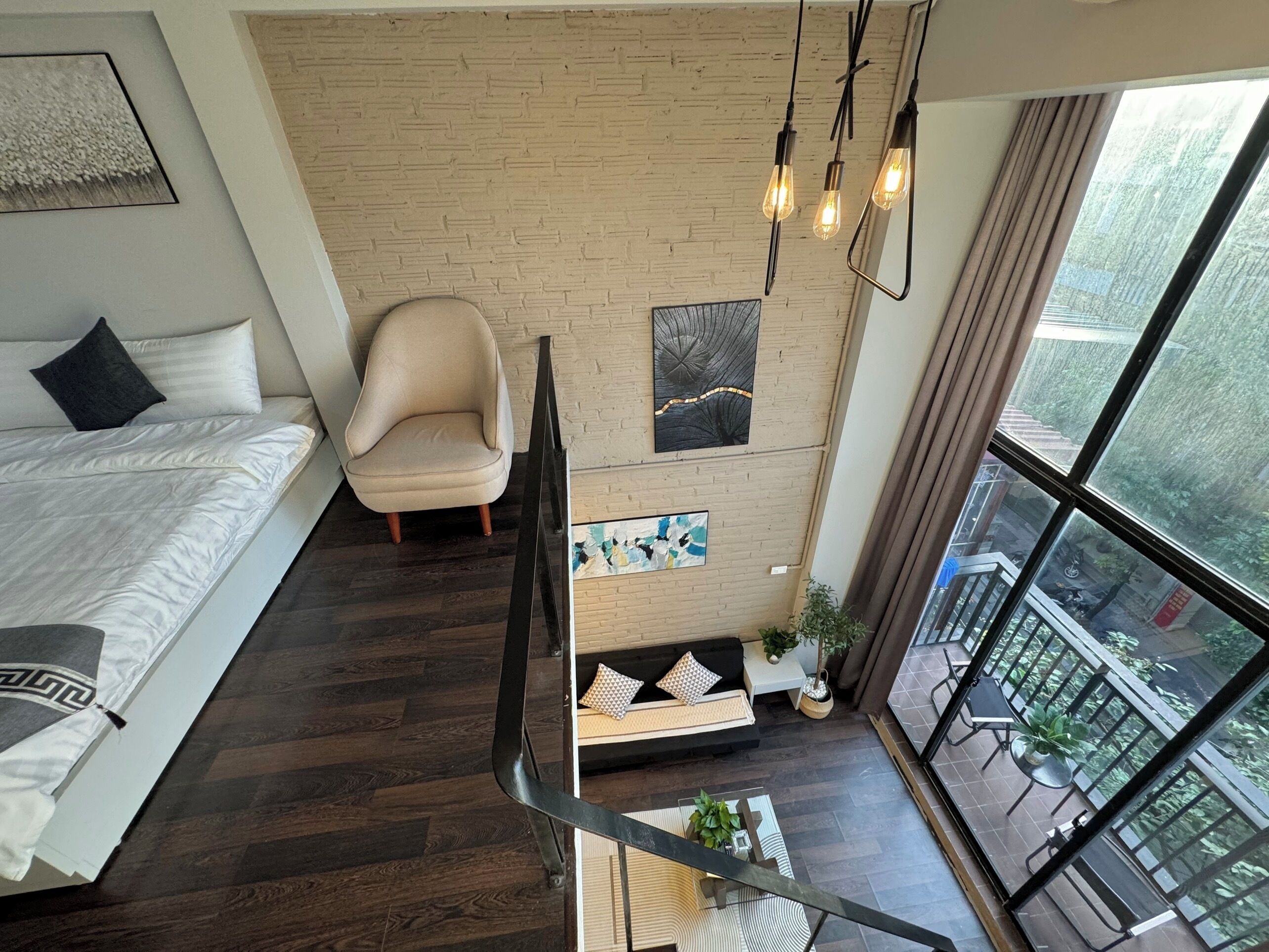 A modern bedroom with a large bed, a chair, and a view of a balcony.