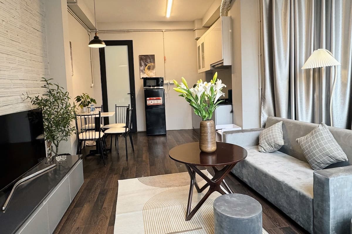 A compact living space with a kitchenette, a dining area, and a seating area with a sofa and a coffee table.