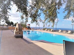 A swimming pool with lounge chairs and a children's play area.