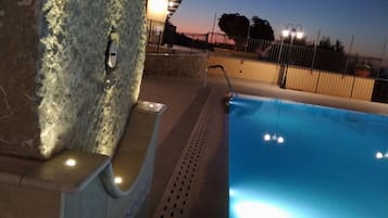 Una piscina con un muro de piedra y una barandilla de metal.