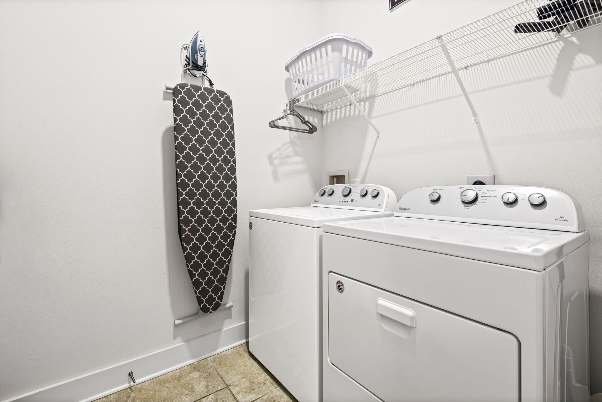 A laundry room with a washing machine, dryer, and a drying rack.
