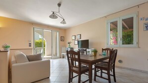Un coin repas avec une table et des chaises en bois, un canapé et un téléviseur.