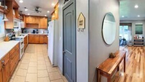 A kitchen with wooden cabinets, a countertop, and a bench.