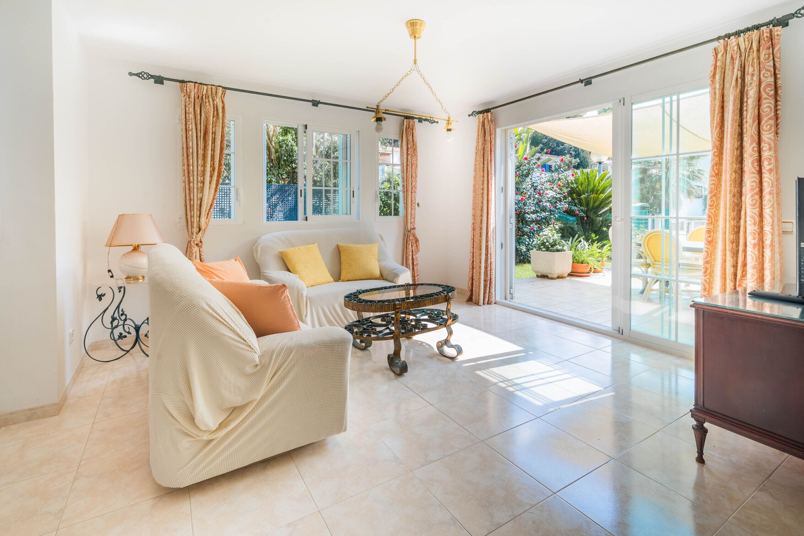 A spacious living room with a sofa, a coffee table, and a television.