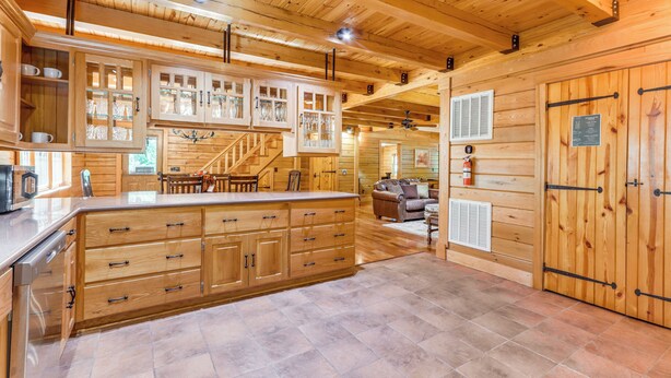 L’intérieur d’un chalet en bois comprend une cuisine, un coin repas et un escalier.