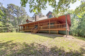 A log cabin with a covered porch and a staircase leading to the main entrance. - Rogers Cabin on 17 Acres w/ Wraparound Deck! (Rogers)