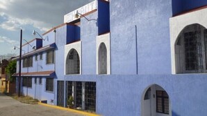 A building with a blue facade, multiple windows, and a visible entrance. - Hotel Huautla de Oaxaca  (Oaxaca)