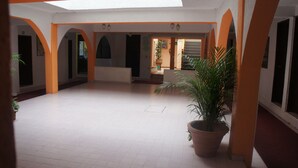 An interior with a tiled floor, orange arches, and a potted plant. - Hotel Huautla de Oaxaca  (Oaxaca)