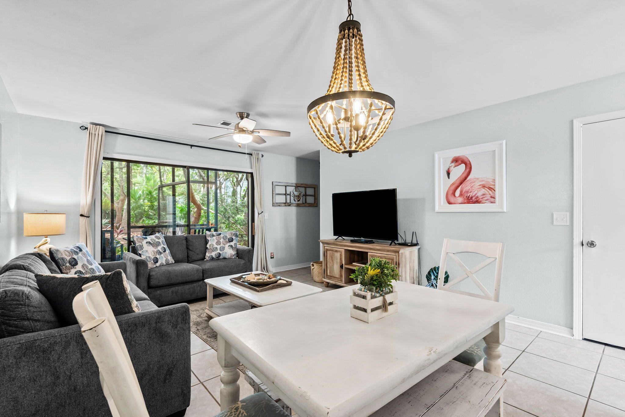 A modern living room with a sofa, coffee table, TV, and a large window.