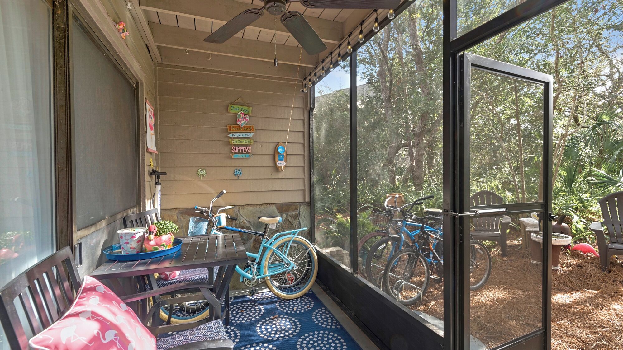 A covered porch with a table, chairs, and a bicycle.
