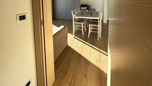 Una cocina moderna con comedor, suelo de madera e iluminación empotrada.