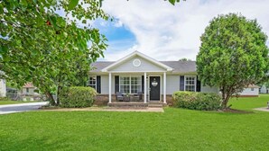 A single-story house with a front porch, a small front yard, and a tree to the left. - Charming House Close to Fort Campbell and Casino (Clarksville)