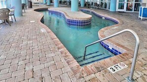 Une piscine intérieure avec un bord carrelé, un sol en briques et un indicateur de profondeur indiquant 3 pieds.